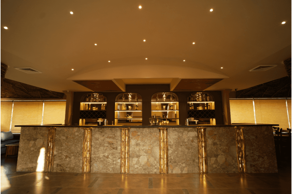 The warm-lit bar with arched, backlit shelves at Azure, a rooftop bar in Panchkula