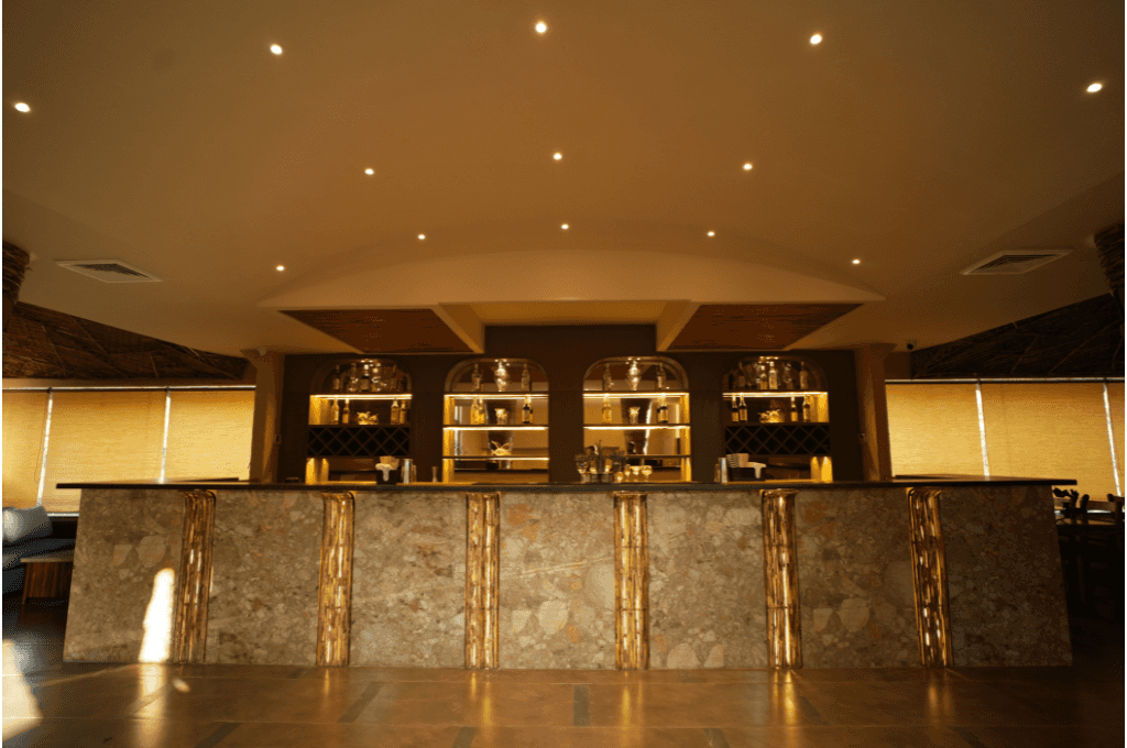 Azure bar counter with warm-lit arched liquor shelves