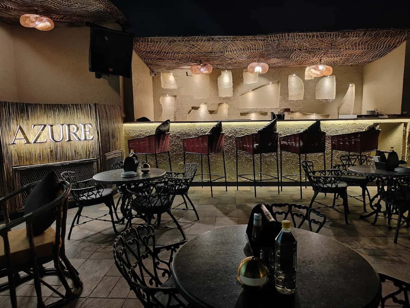 Evening garden bar at Azure under a rattan canopy with warm lighting