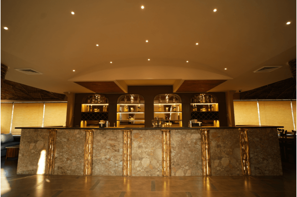 Warm-lit bar with arched backlit shelves at Azure